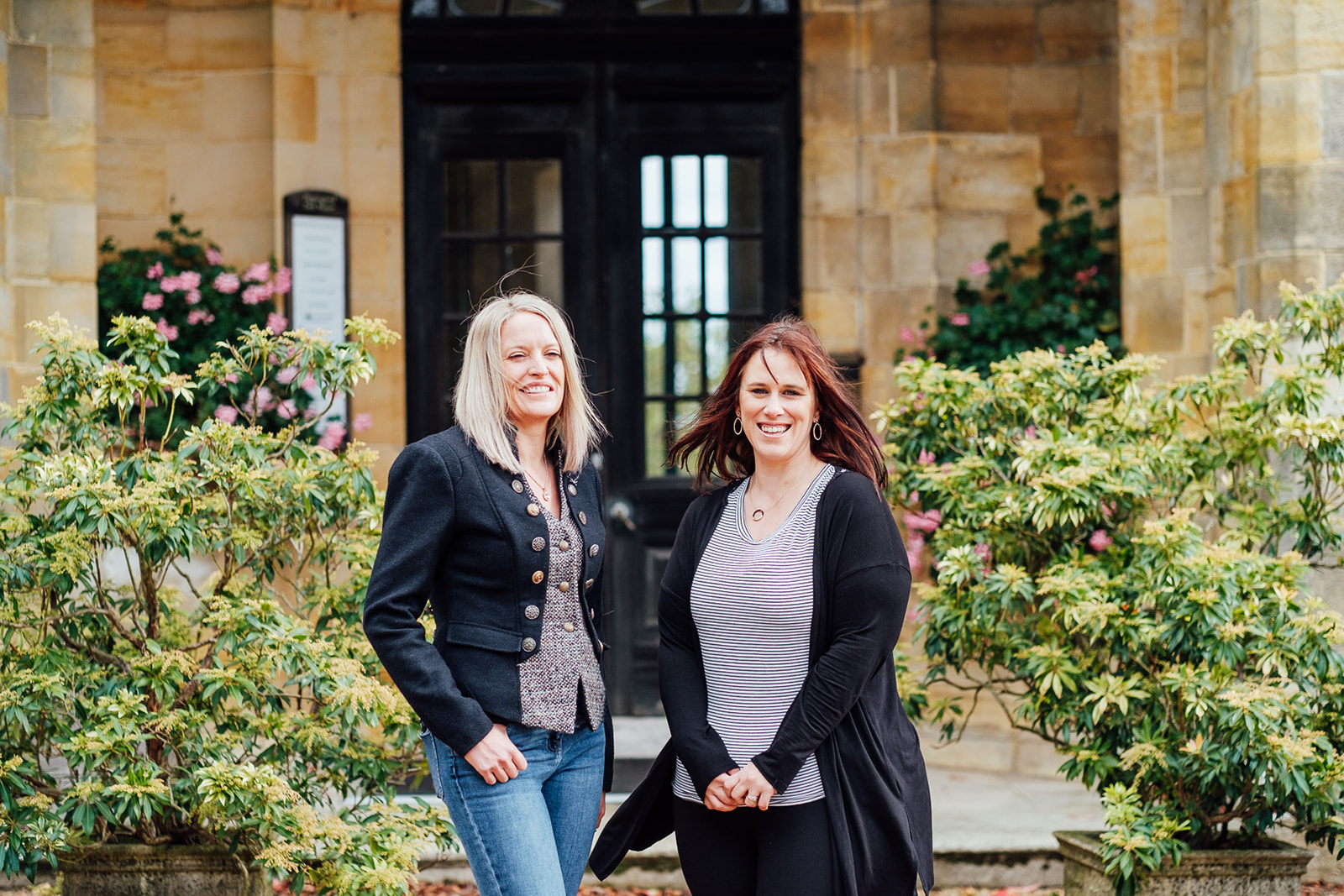 Sarah Morgan-Kelly and Emma Gearing photographed in front of a heritage sandstone portico, the firm's Sussex setting.